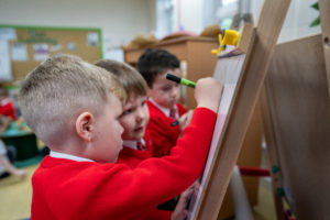 Group of students gathered around a whiteboard during a lesson.